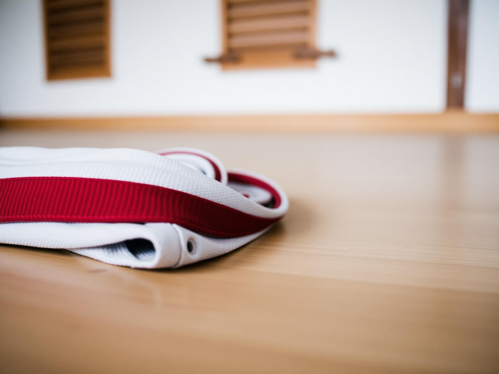 A folded taekwondo belt resting on the dojang floor